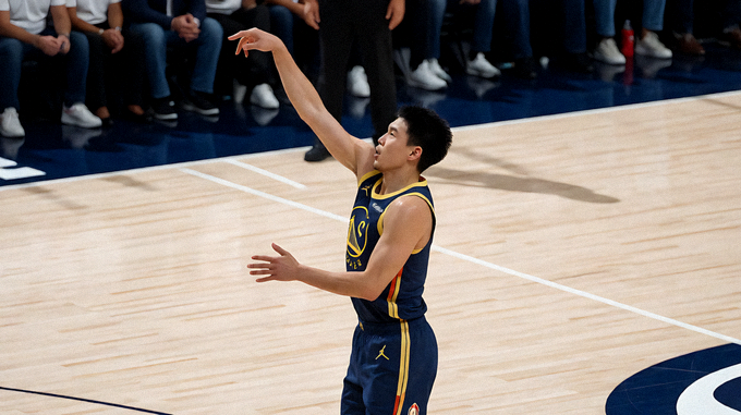 NBA篮球比赛现场，球员在三分线外出手投篮
